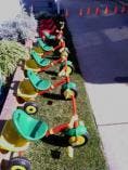 Row of children's scooters parked on grass