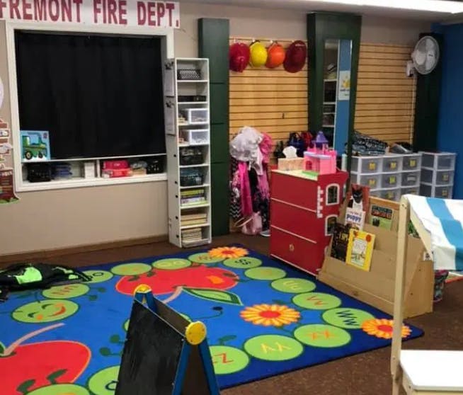 Classroom with a colorful rug, shelves, and a window