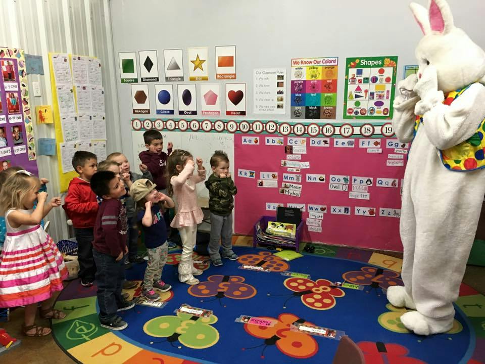 Children looking at a person in a bunny costume in a classroom