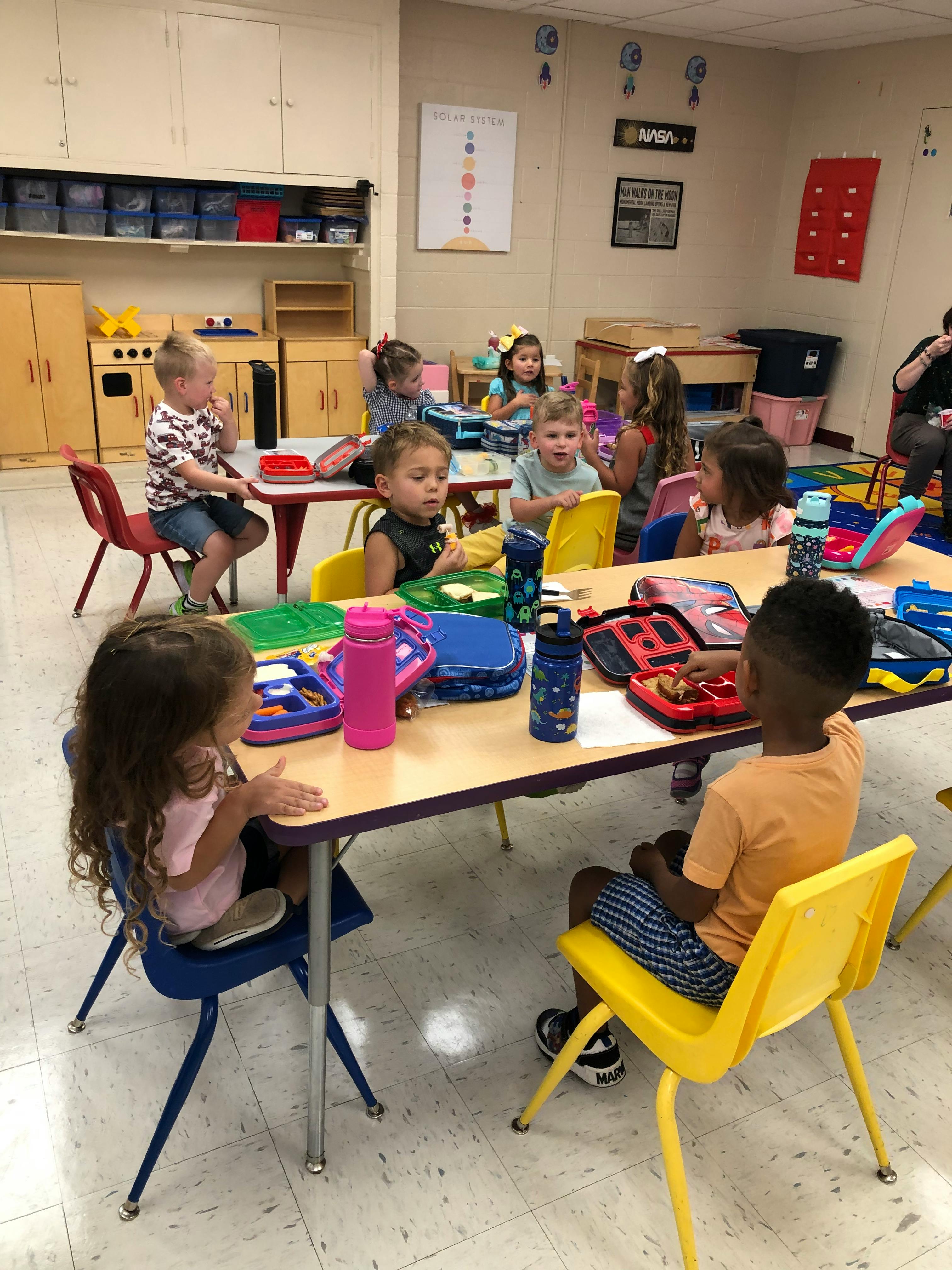 Children sitting at tables in a classroom