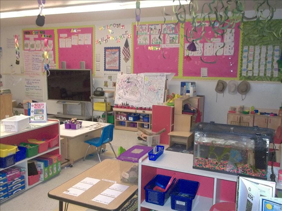 Classroom with desks, bulletin boards, a TV, an easel, and a fish tank