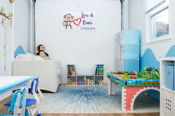 Childcare room with toys, books, and a sign that says "Love & Care Childcare"