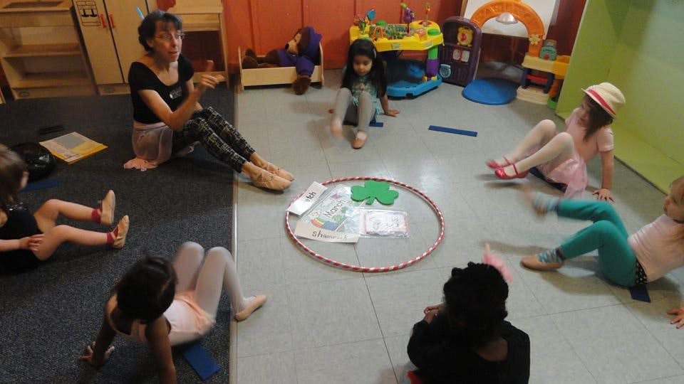Adult and children sitting on floor in a circle