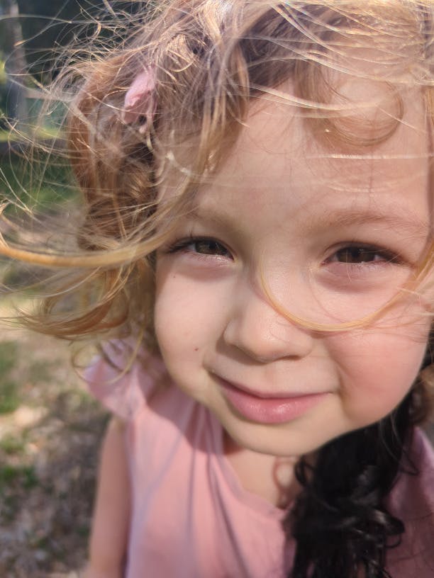 Close up of a child's face with curly hair