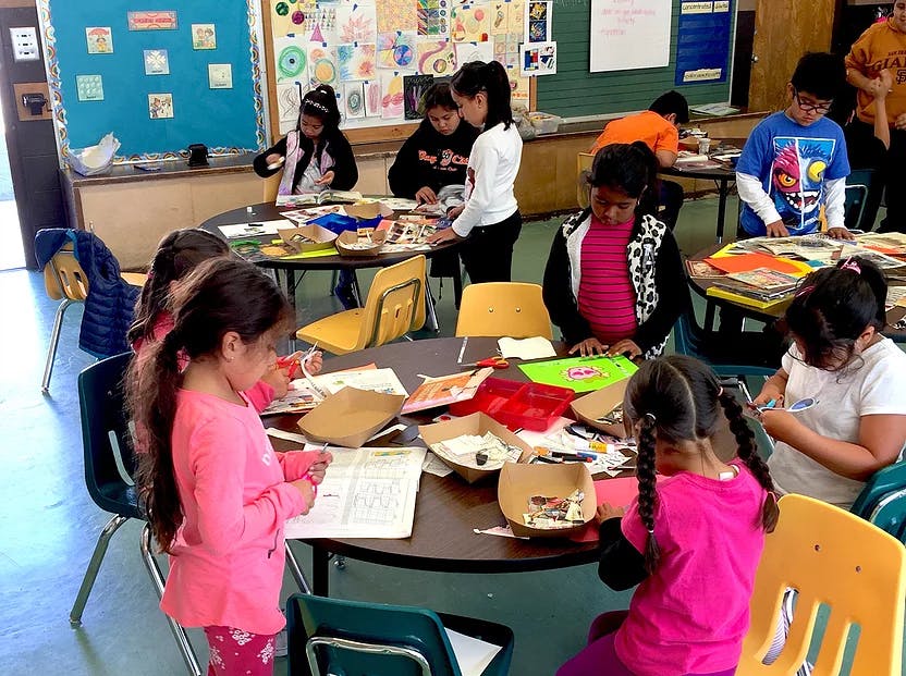 Children working on art projects at tables in a classroom