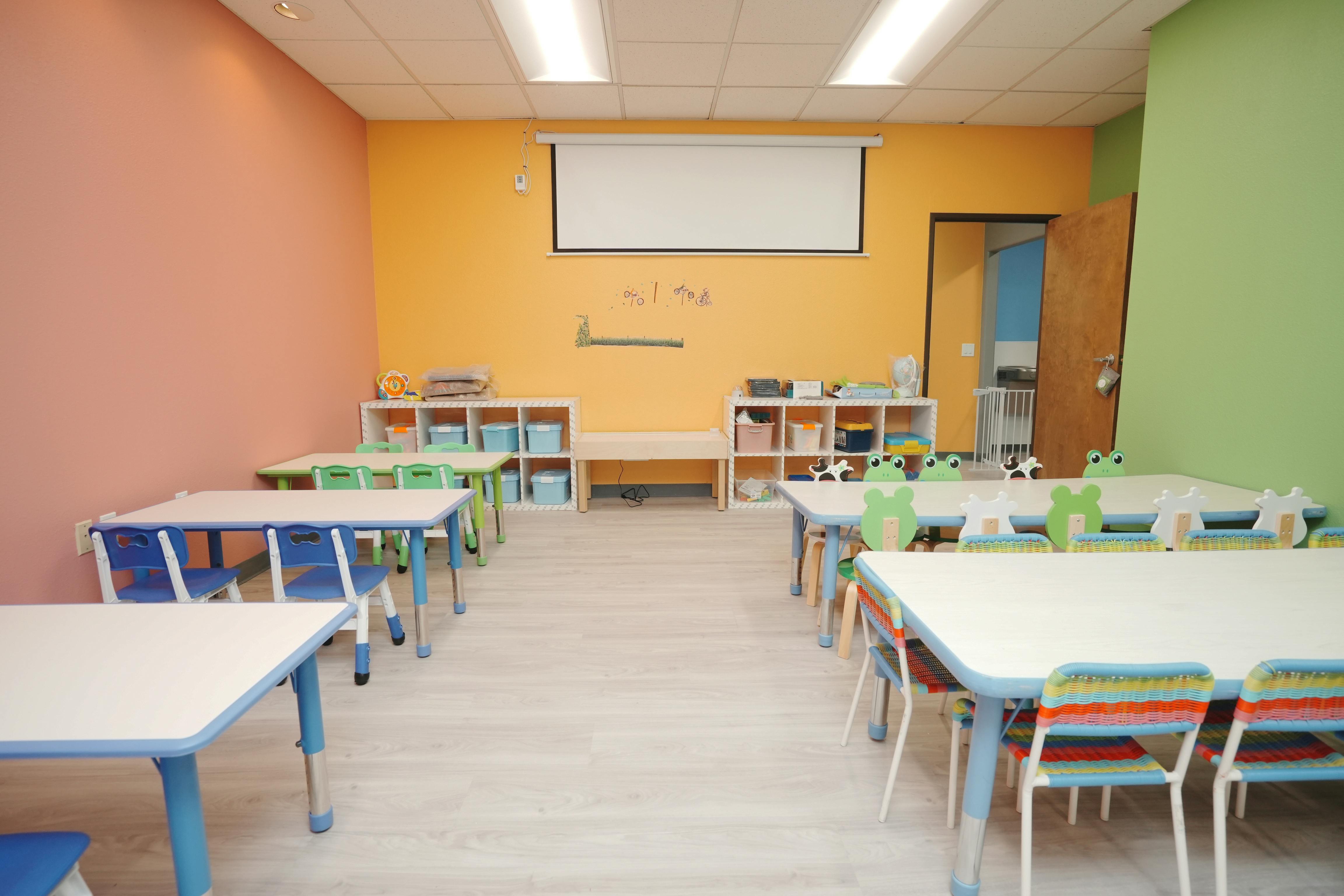Empty classroom with small tables and chairs