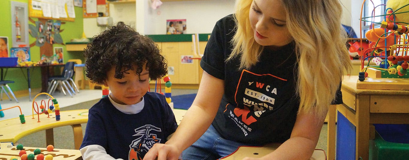 Person and child playing with toys at a table