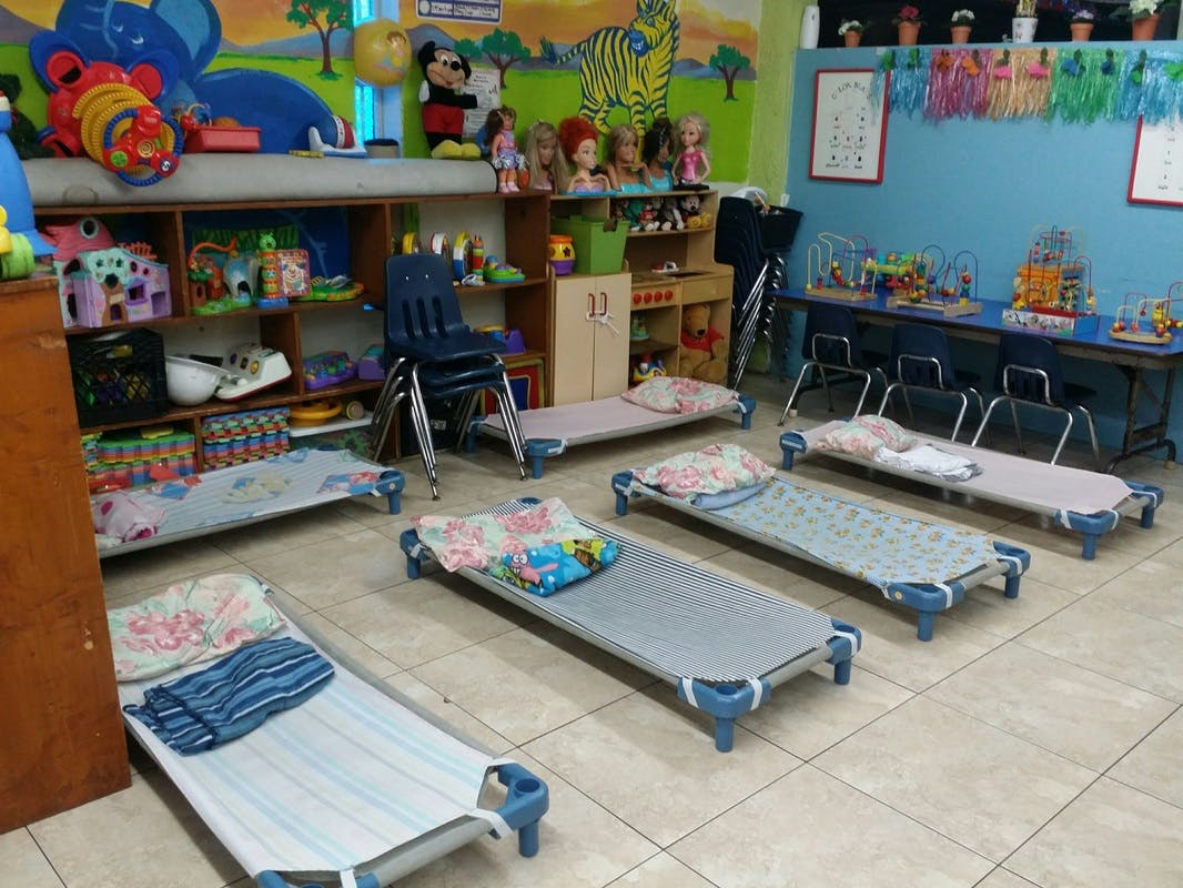 Child-sized cots with bedding in a colorful classroom