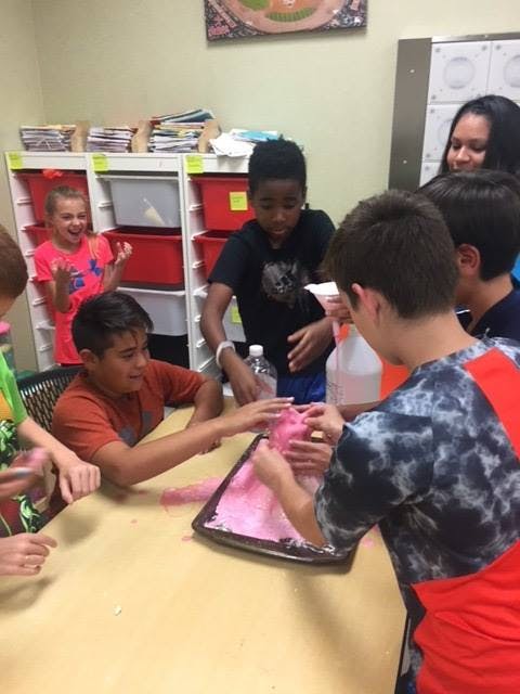 Children making pink slime at a table