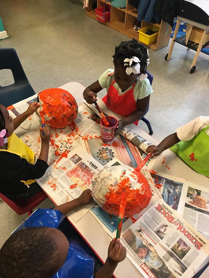 Children painting papier-mache pumpkins