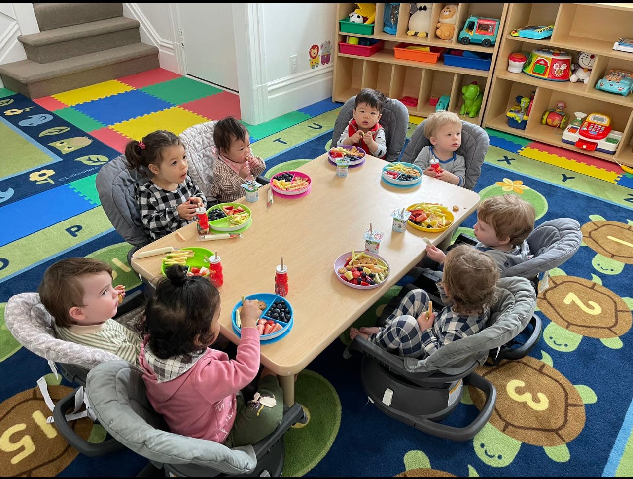 Children eating at a table in a classroom
