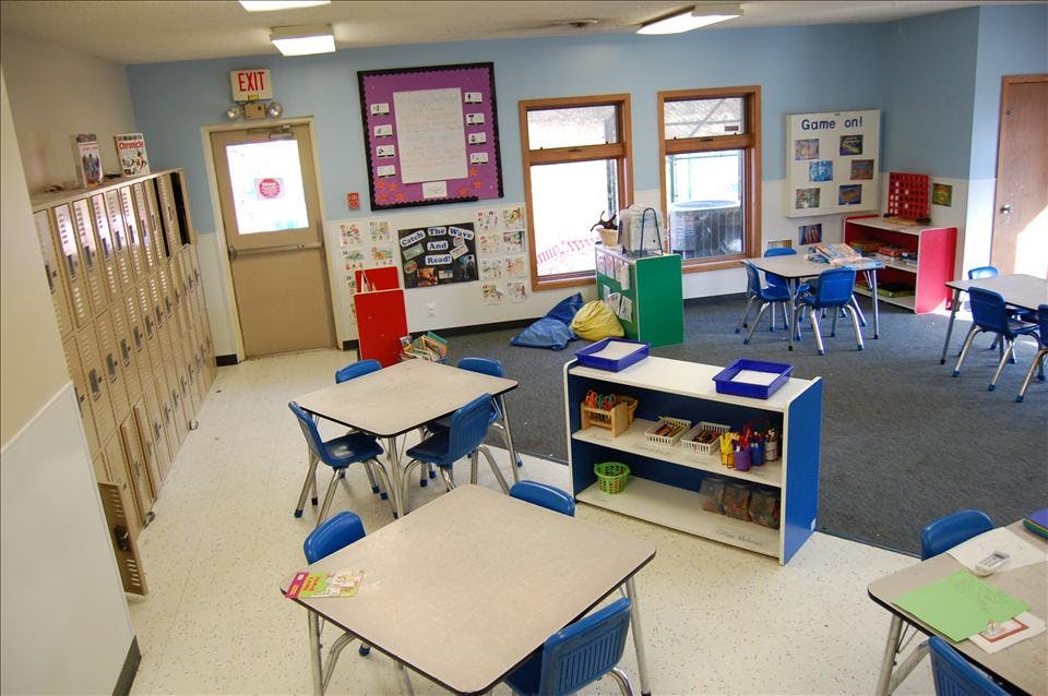 Classroom with small tables and chairs, lockers, and learning materials