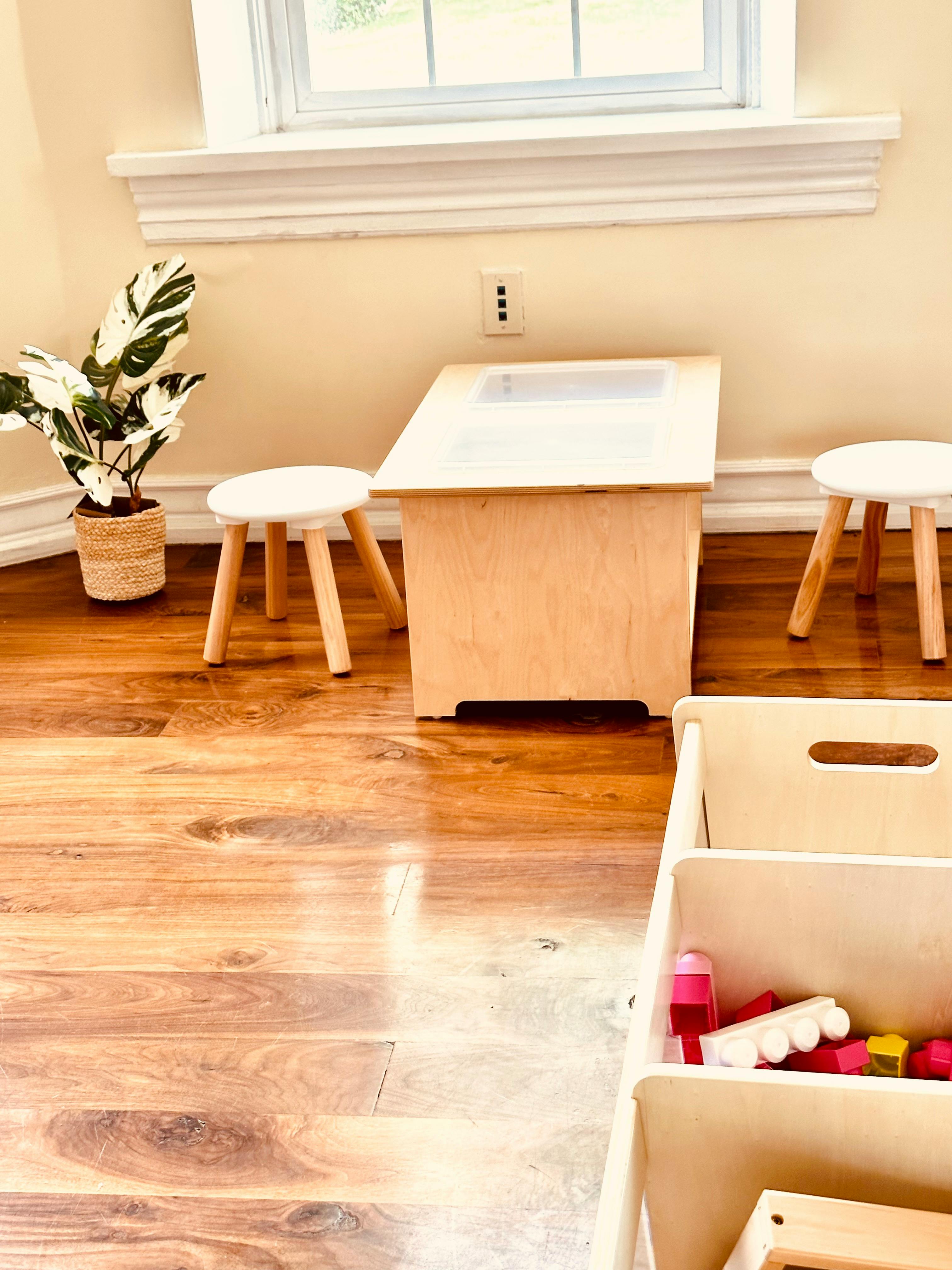 Small wooden table with two stools and a potted plant