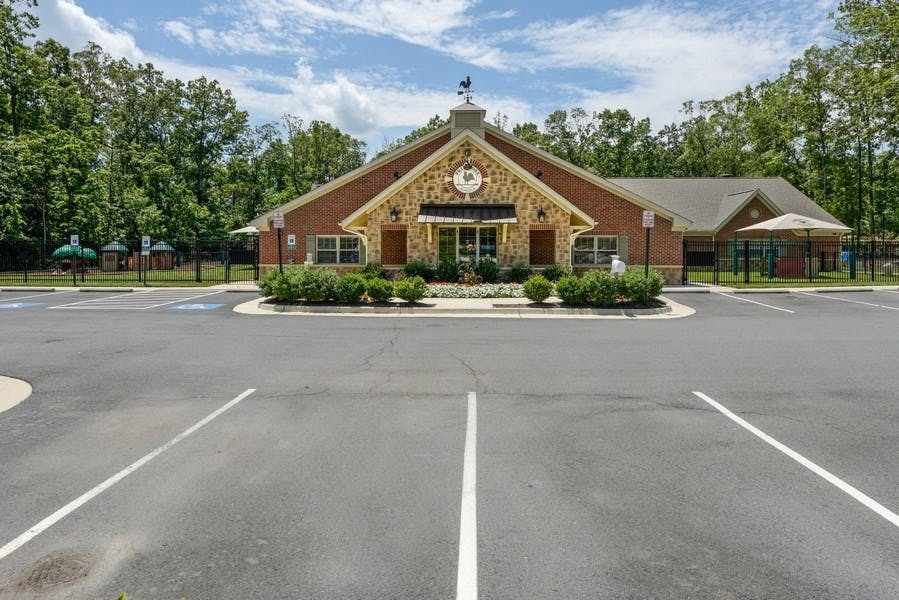 Building with a stone and brick facade and a parking lot in front