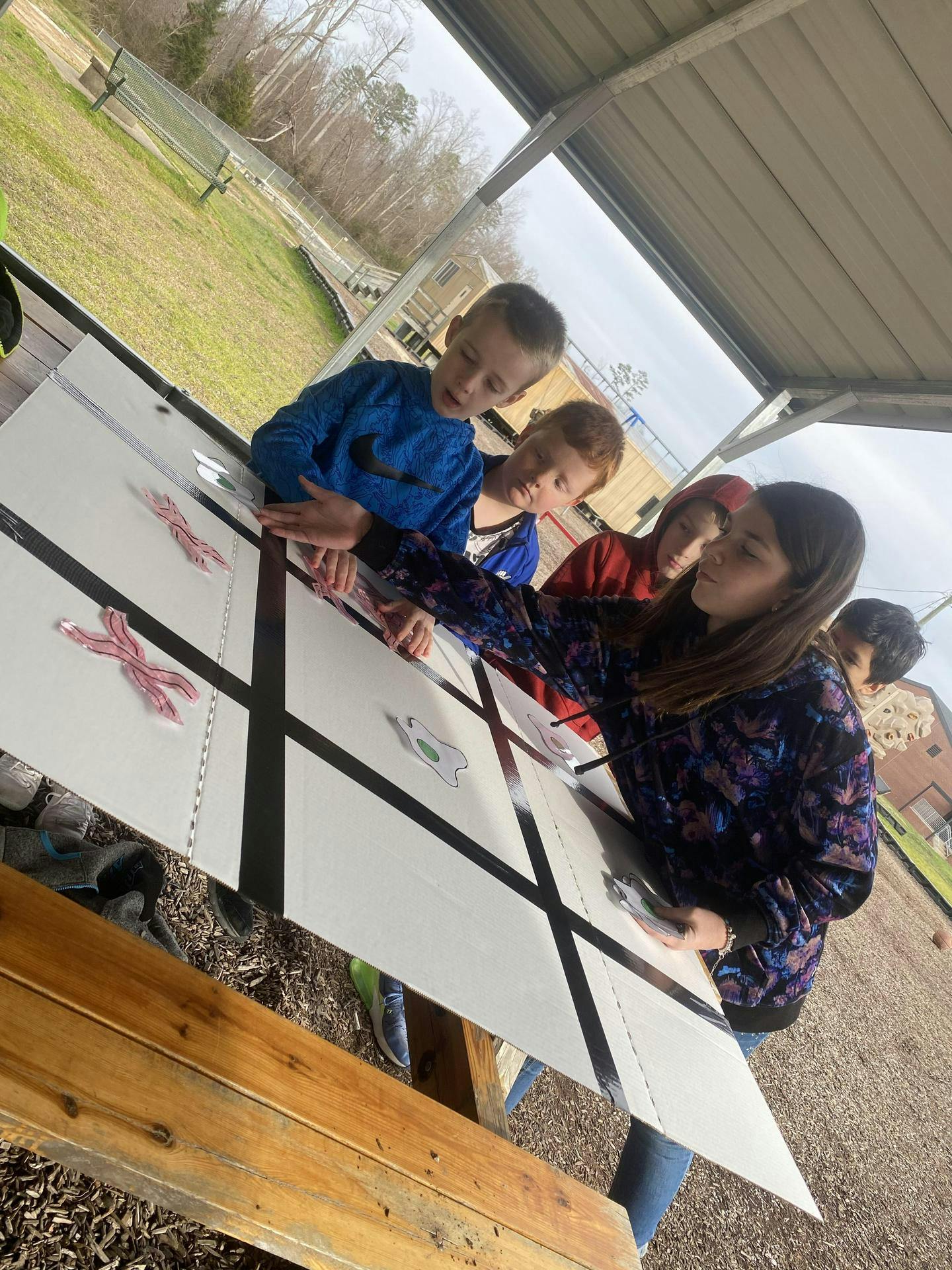 Adult and children looking at a large tic-tac-toe board