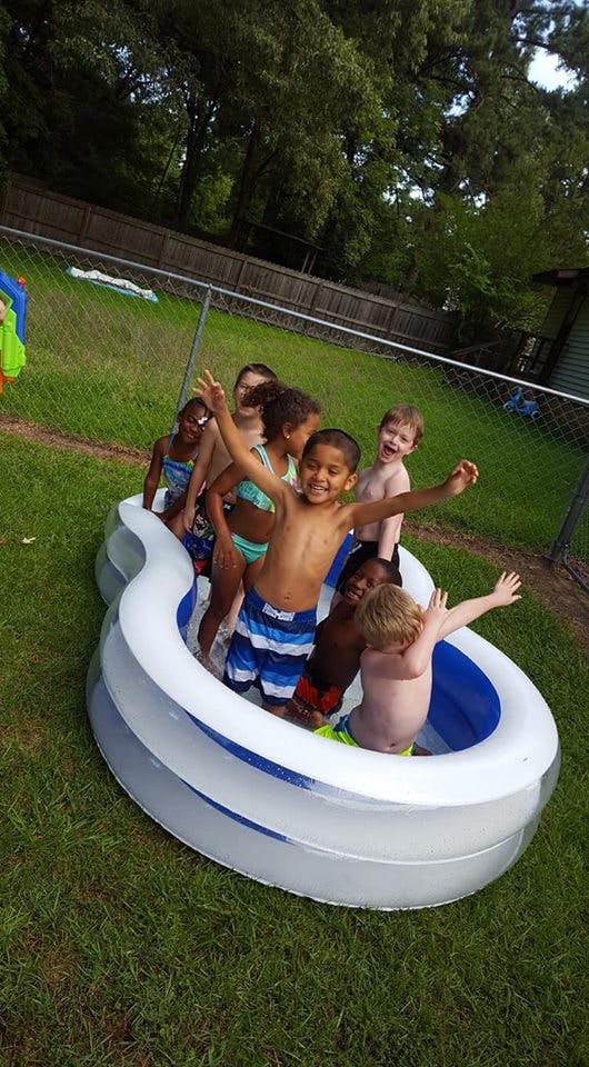 Children playing in an inflatable pool outdoors