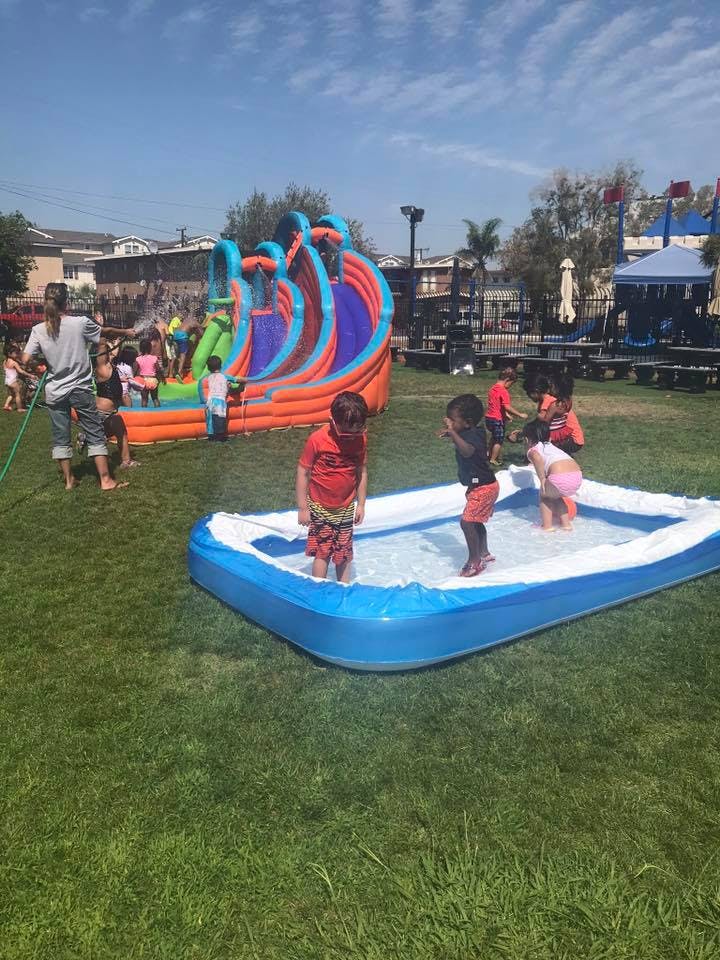 Children playing in an inflatable pool and on a large inflatable slide