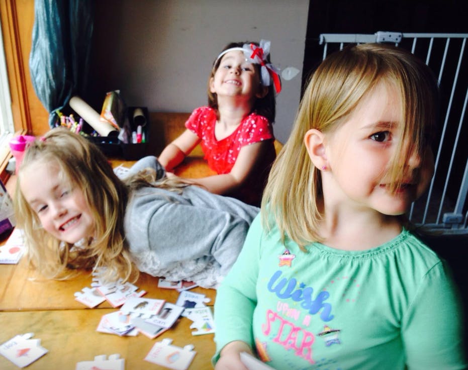 Three children playing with puzzle pieces