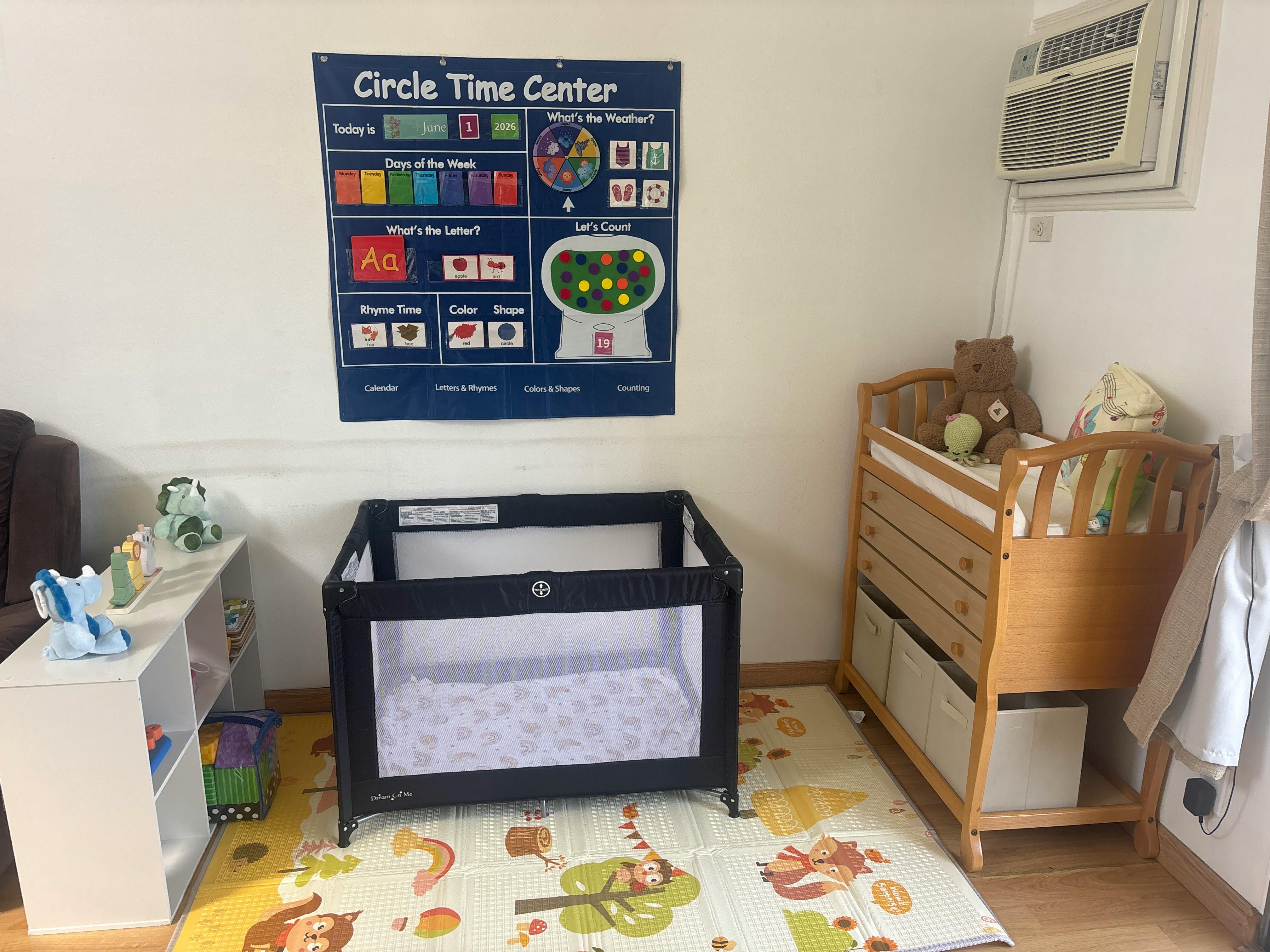 A playroom with a blue Circle Time Center chart, a pack-and-play, and a changing table