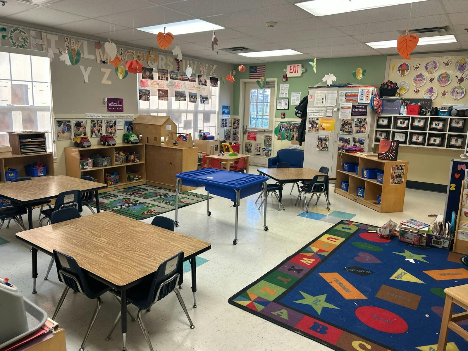 Empty colorful children's classroom with small tables and chairs