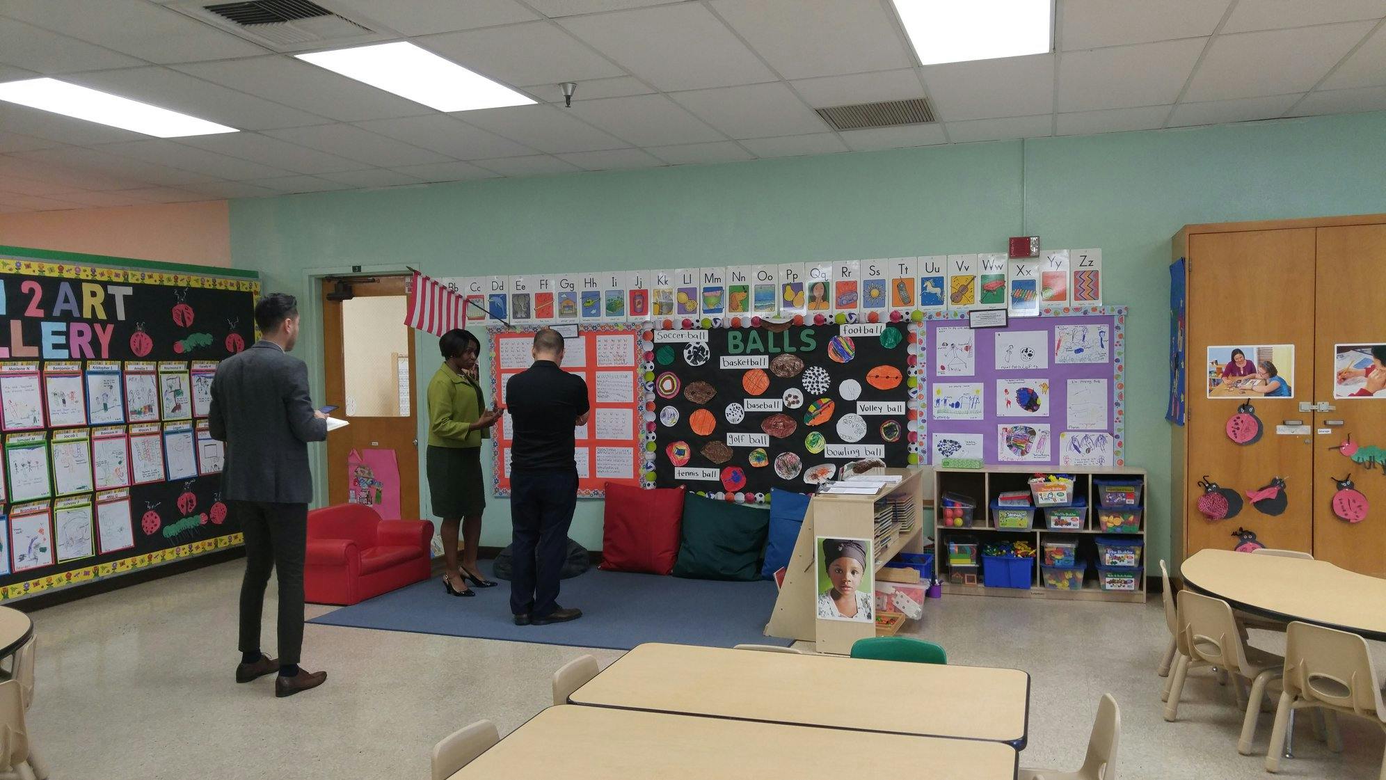 Three people standing in a classroom