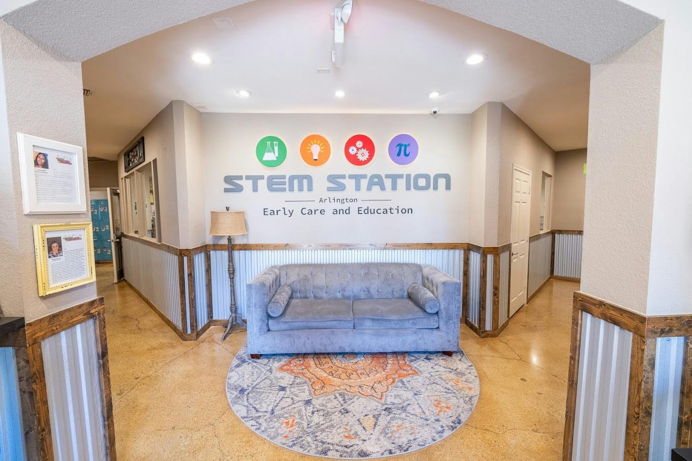Lobby area with a grey sofa and sign reading STEM Station Early Care and Education