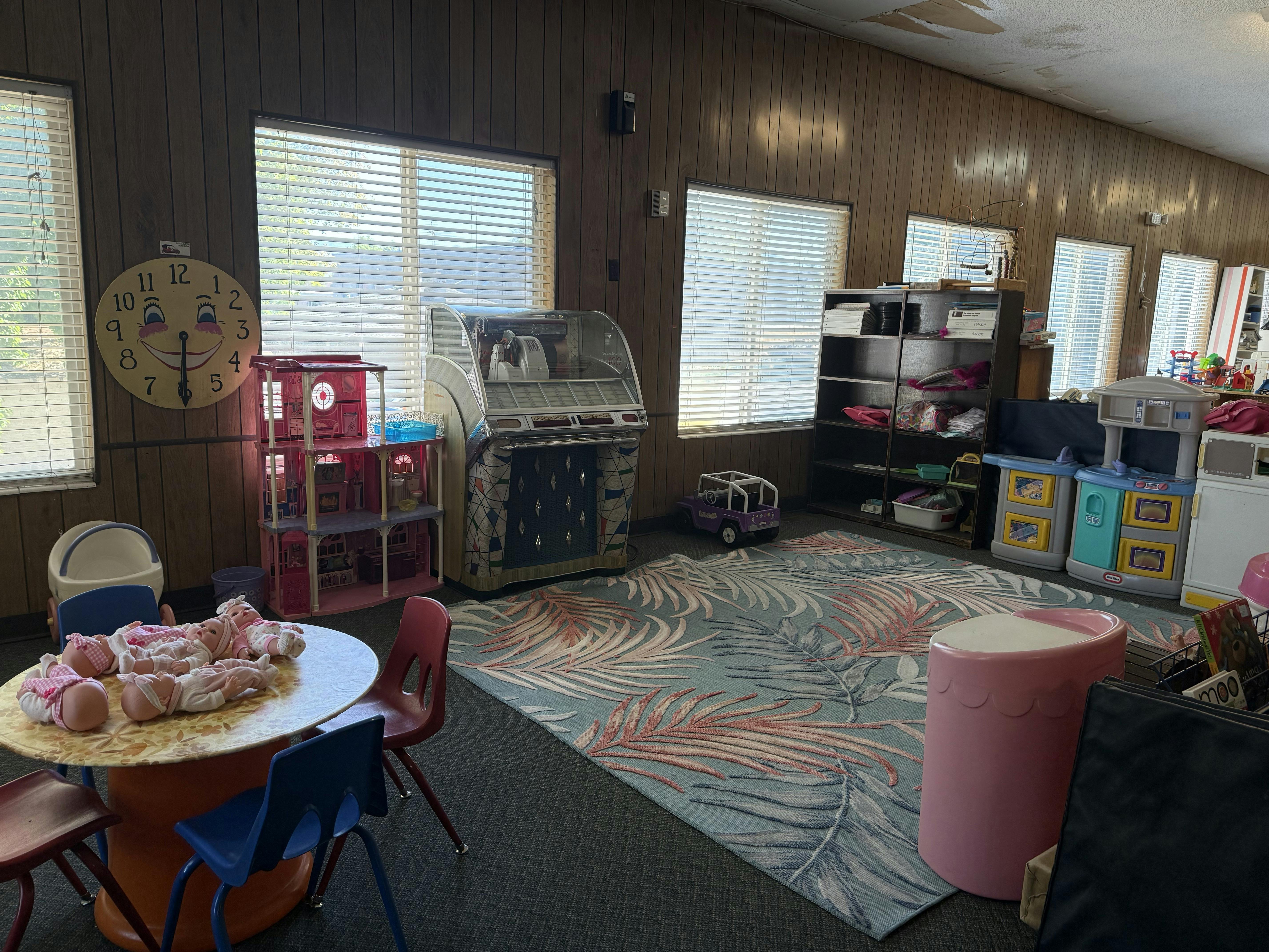 Playroom with small table and chairs, toys, and a patterned rug