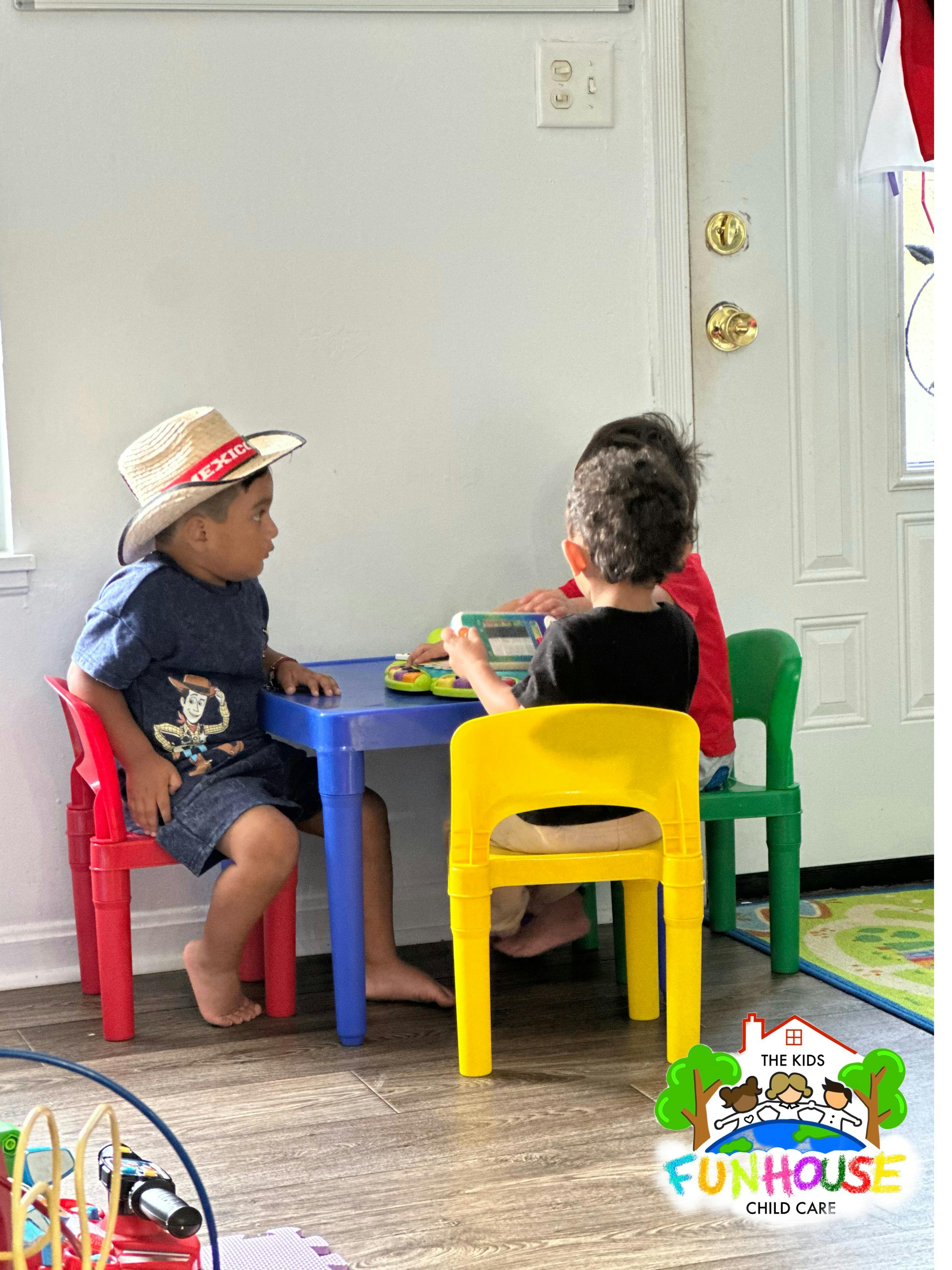 Three children playing with toys at a small table
