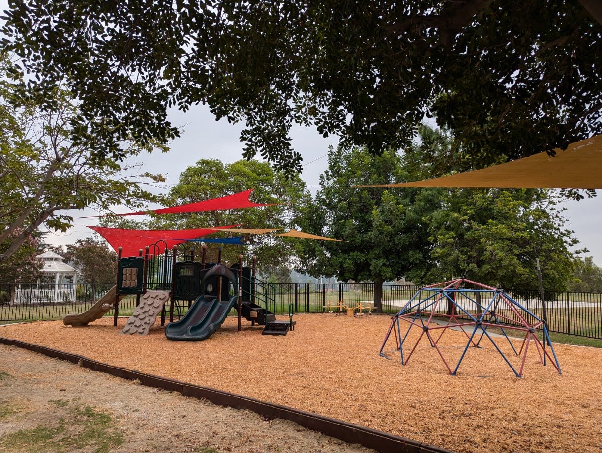 Playground with slides, climbing structure, and shade sails