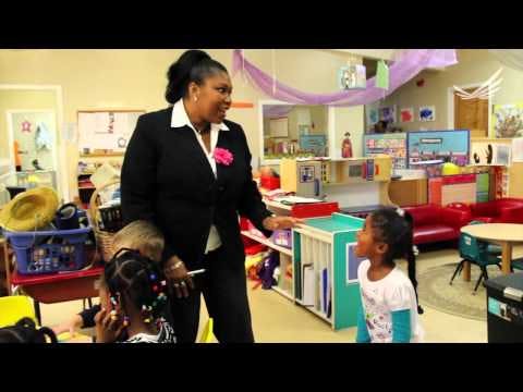 Person in suit talking to children in a classroom
