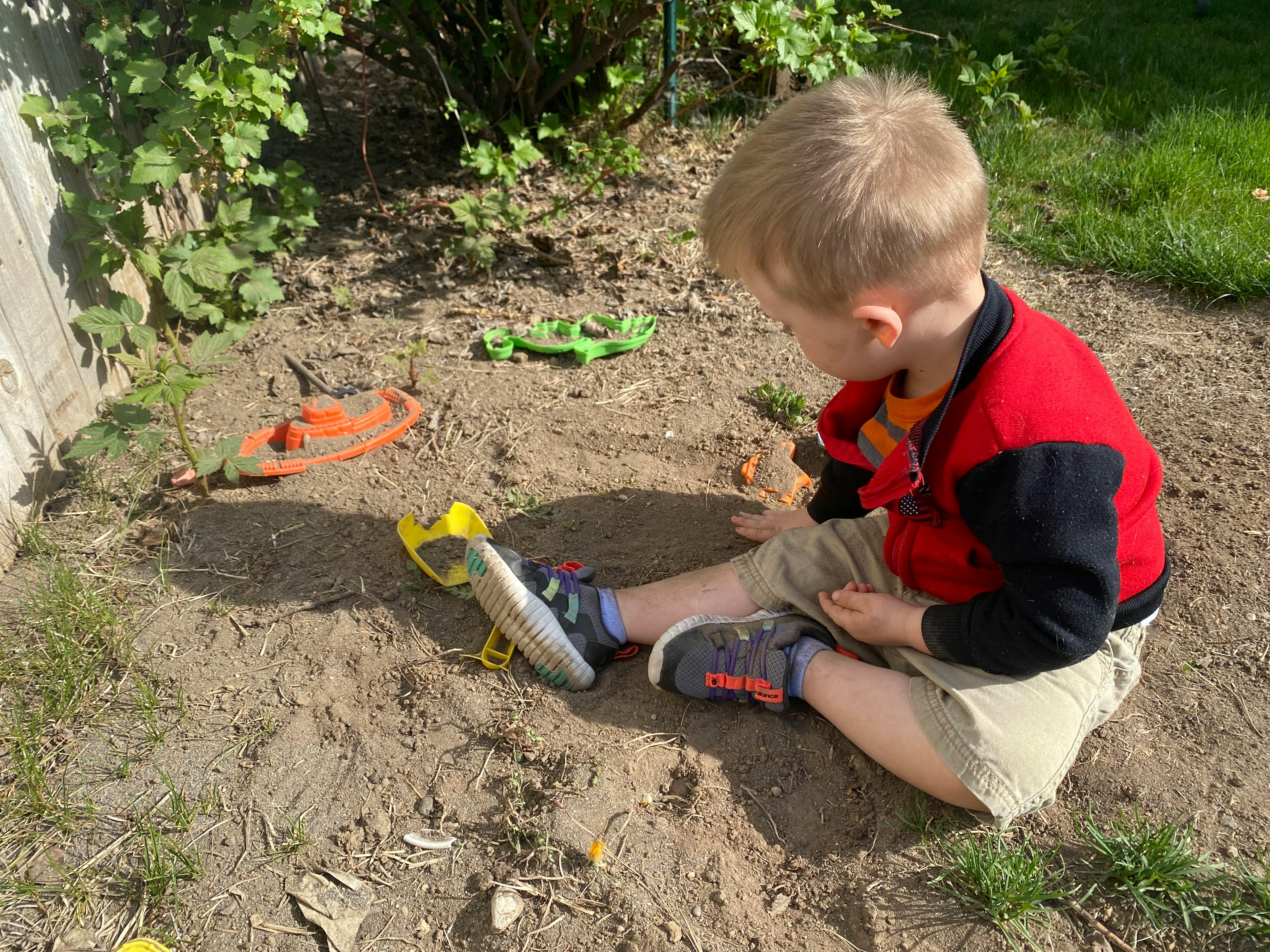 Child sitting on the ground playing with toys