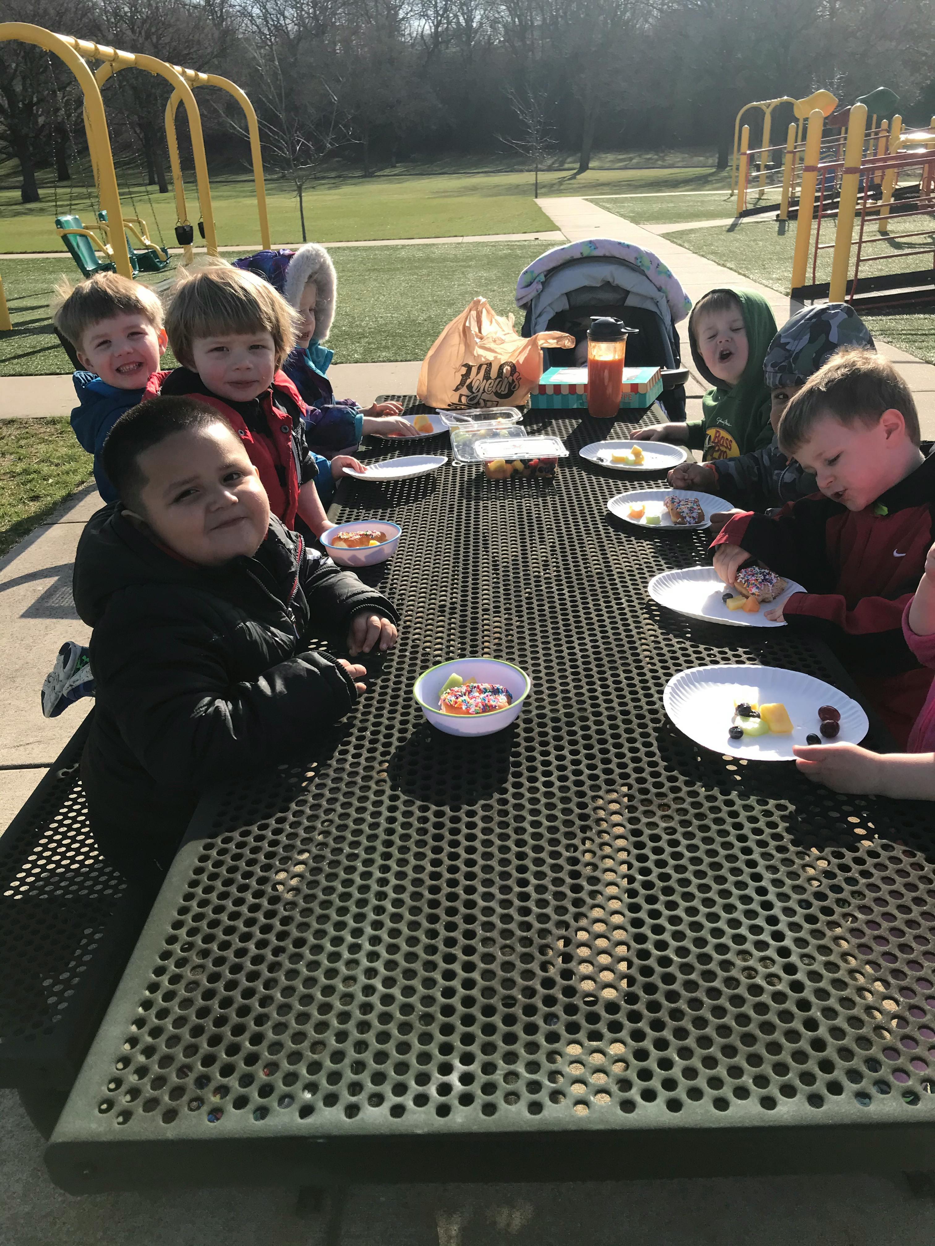 Children eating at a picnic table outdoors