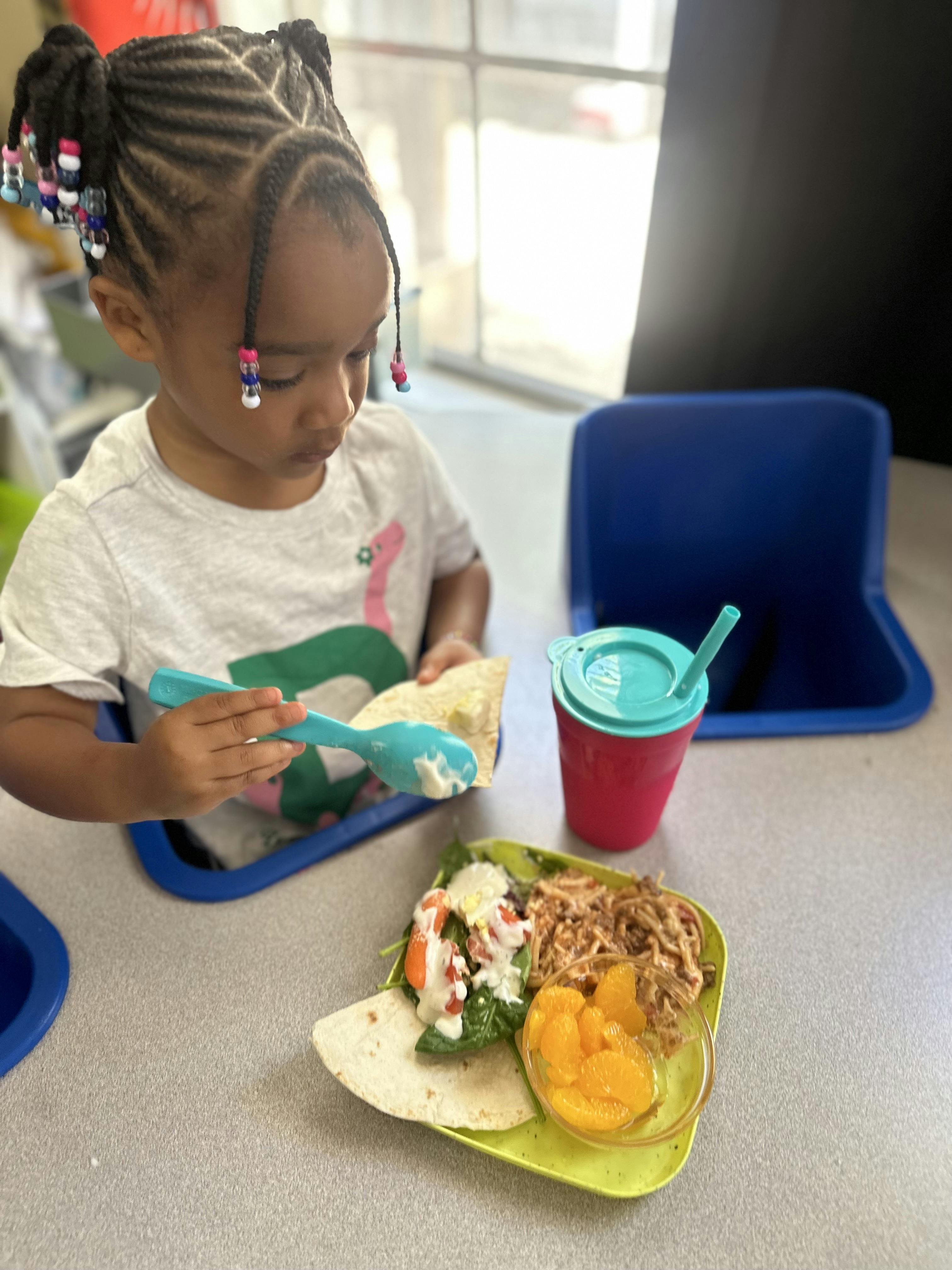 Child eating a meal with a spoon