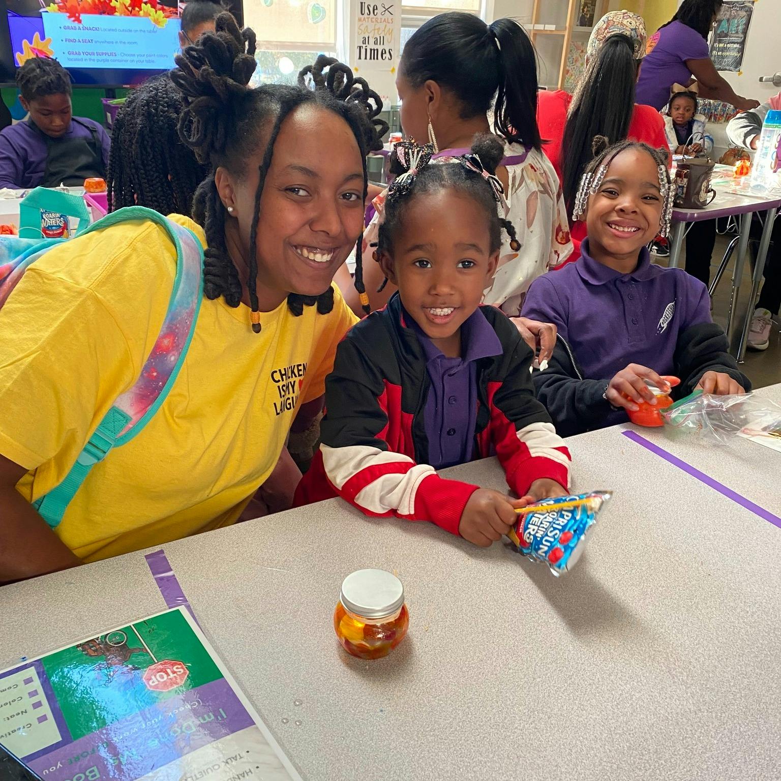 Person and two children smiling at a table