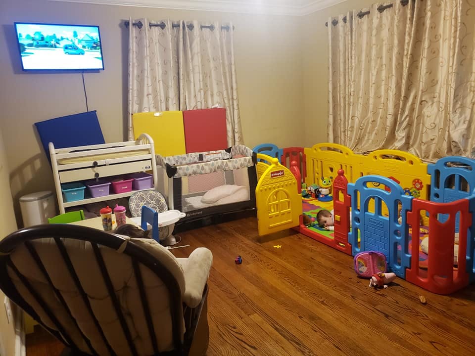 Room with multiple playpens, a crib, and a changing table