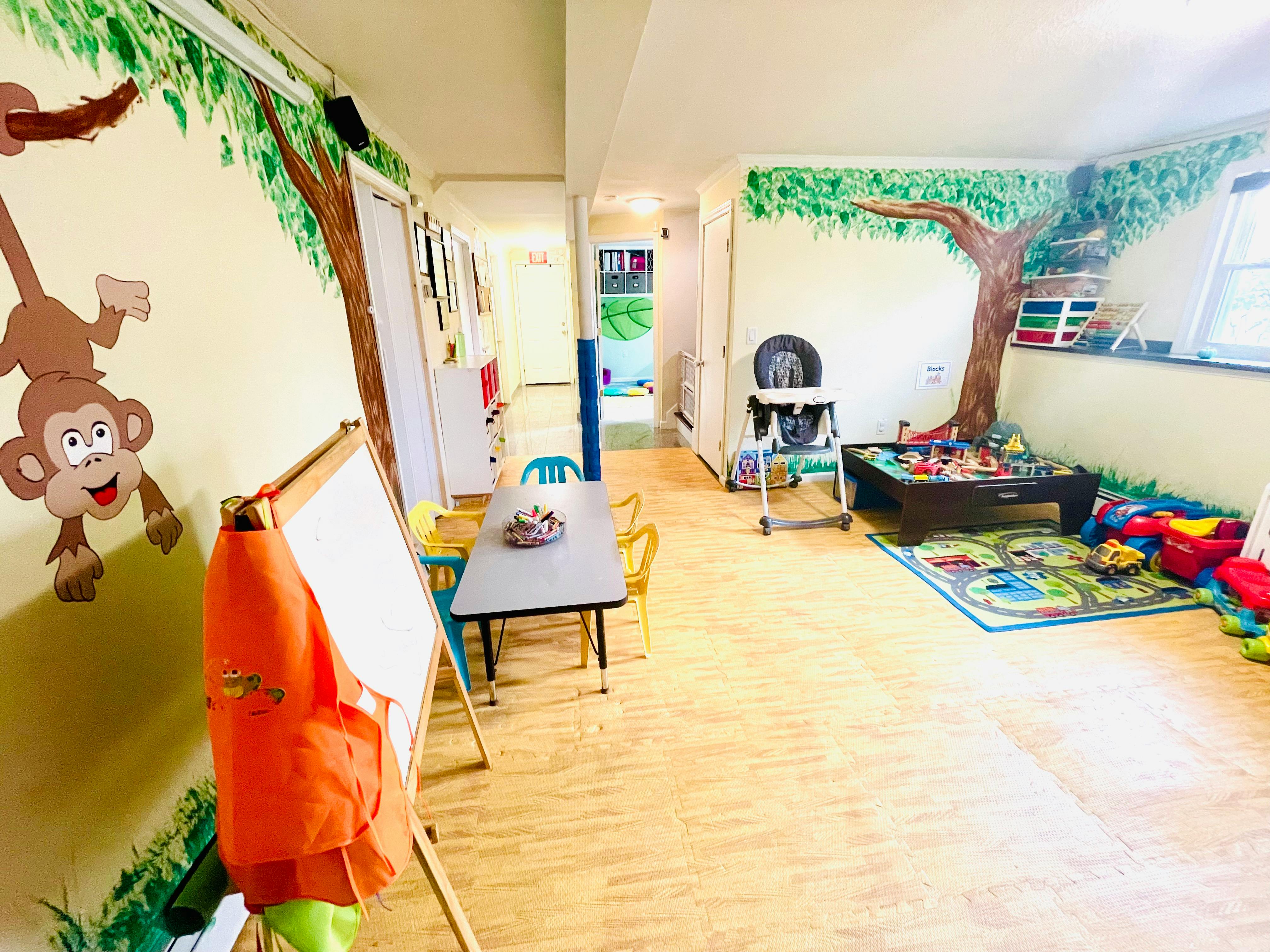 Playroom with tables, chairs, and wall murals