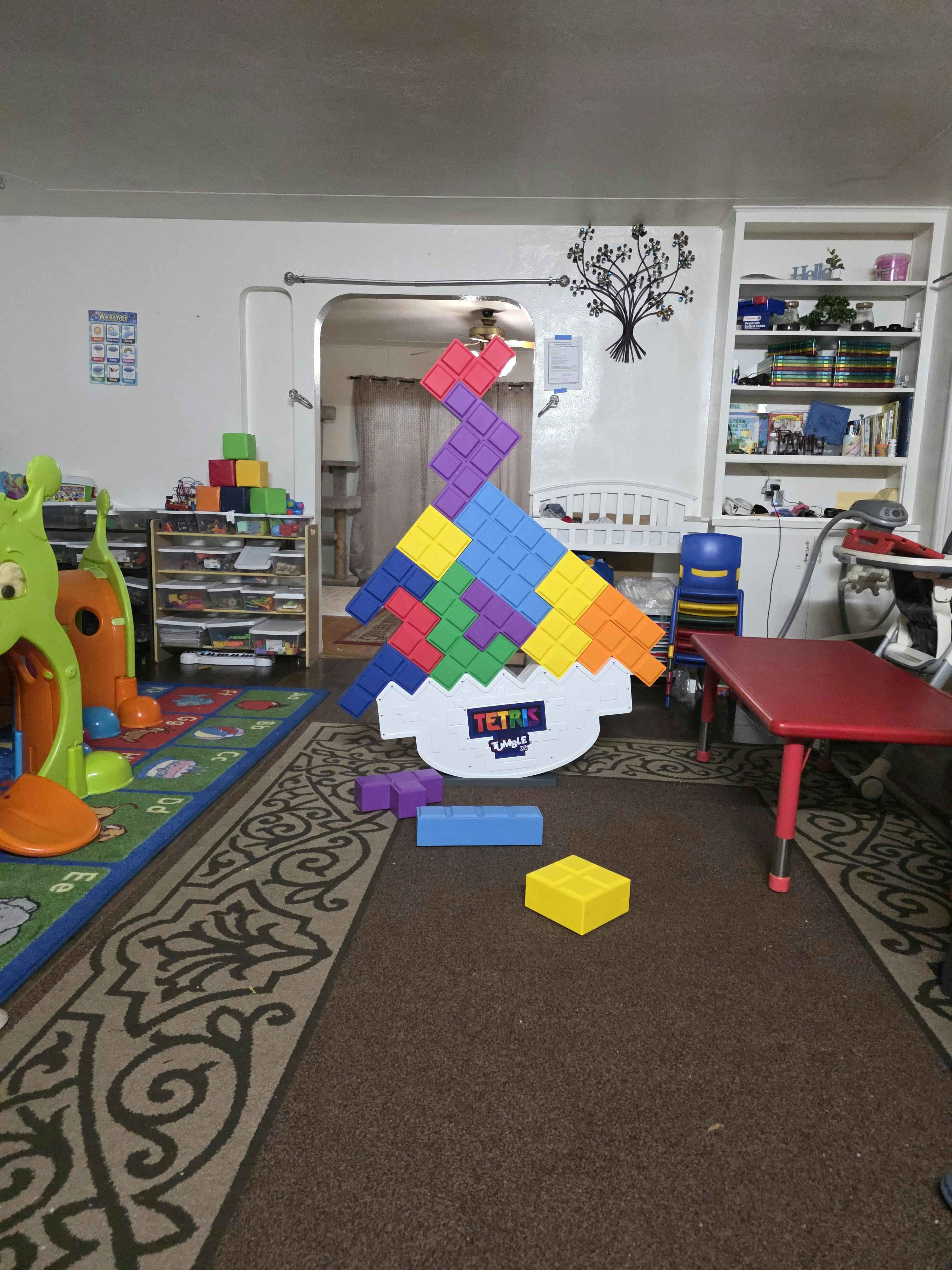 Large Tetris-like puzzle game in a playroom with colorful blocks