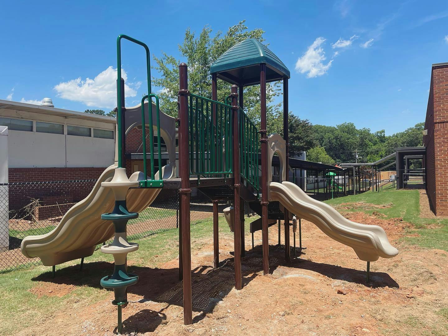 Playground structure with two slides and climbing elements