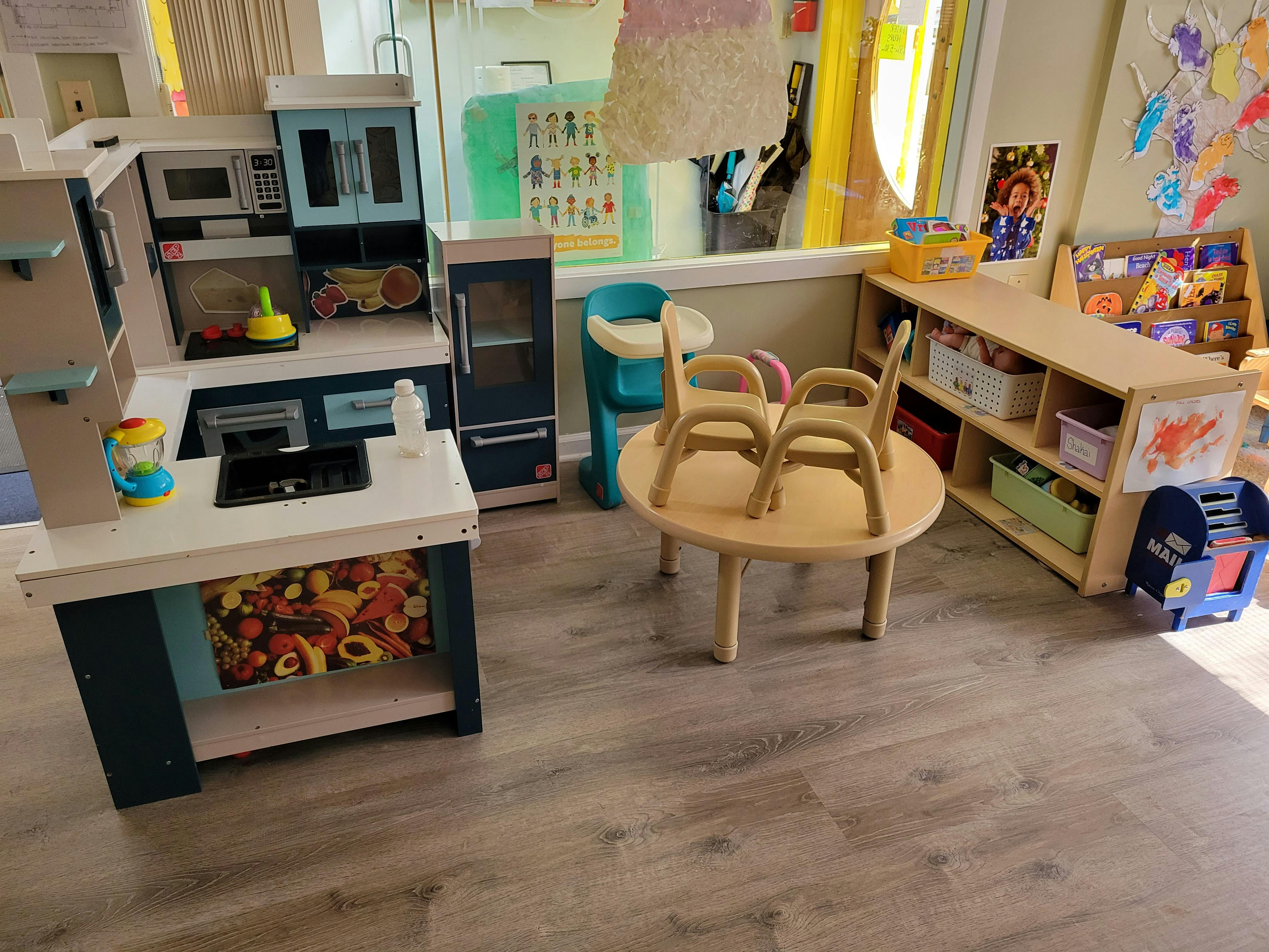 Play kitchen set with a small table and chairs in a classroom