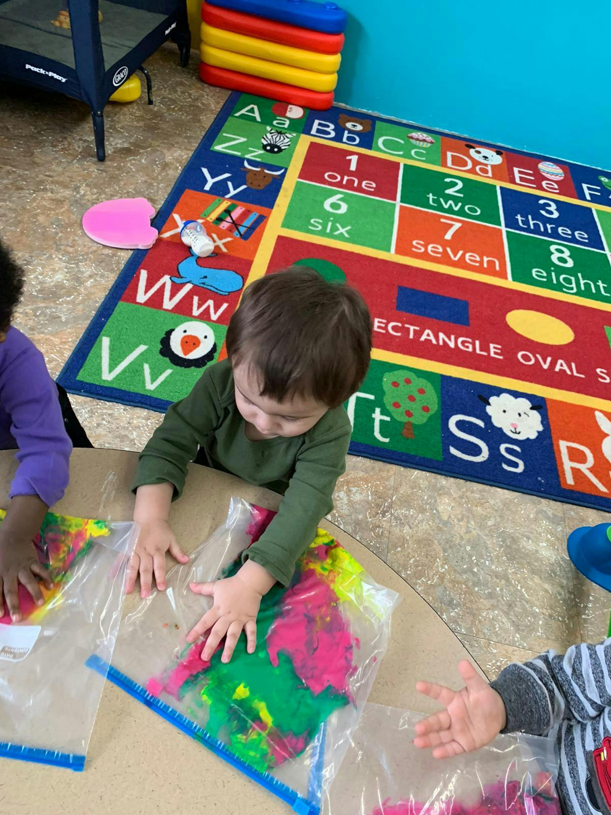 Child playing with paint in a plastic bag