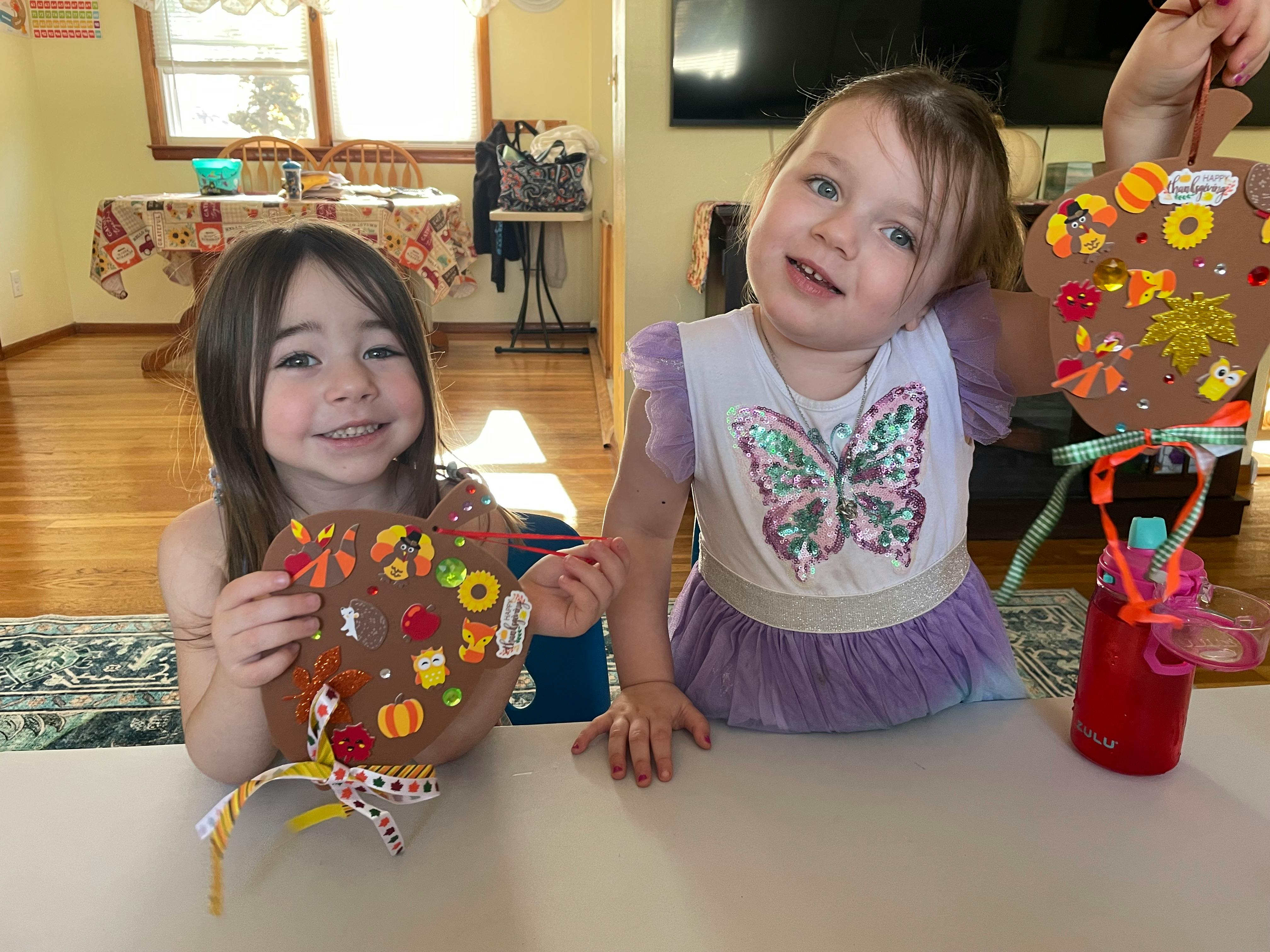 Two children holding decorated pumpkin cutouts