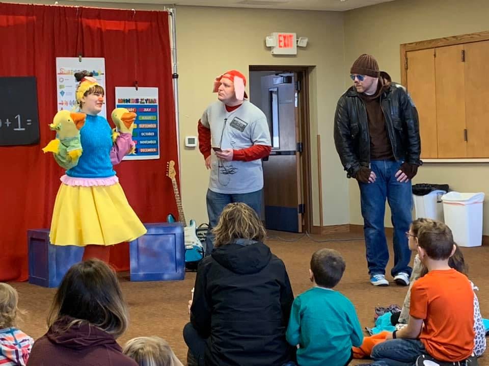 People performing for an audience of adults and children