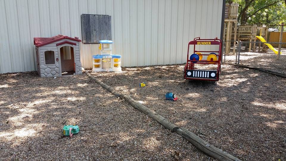Playground with a playhouse, basketball hoop, and toy fire truck