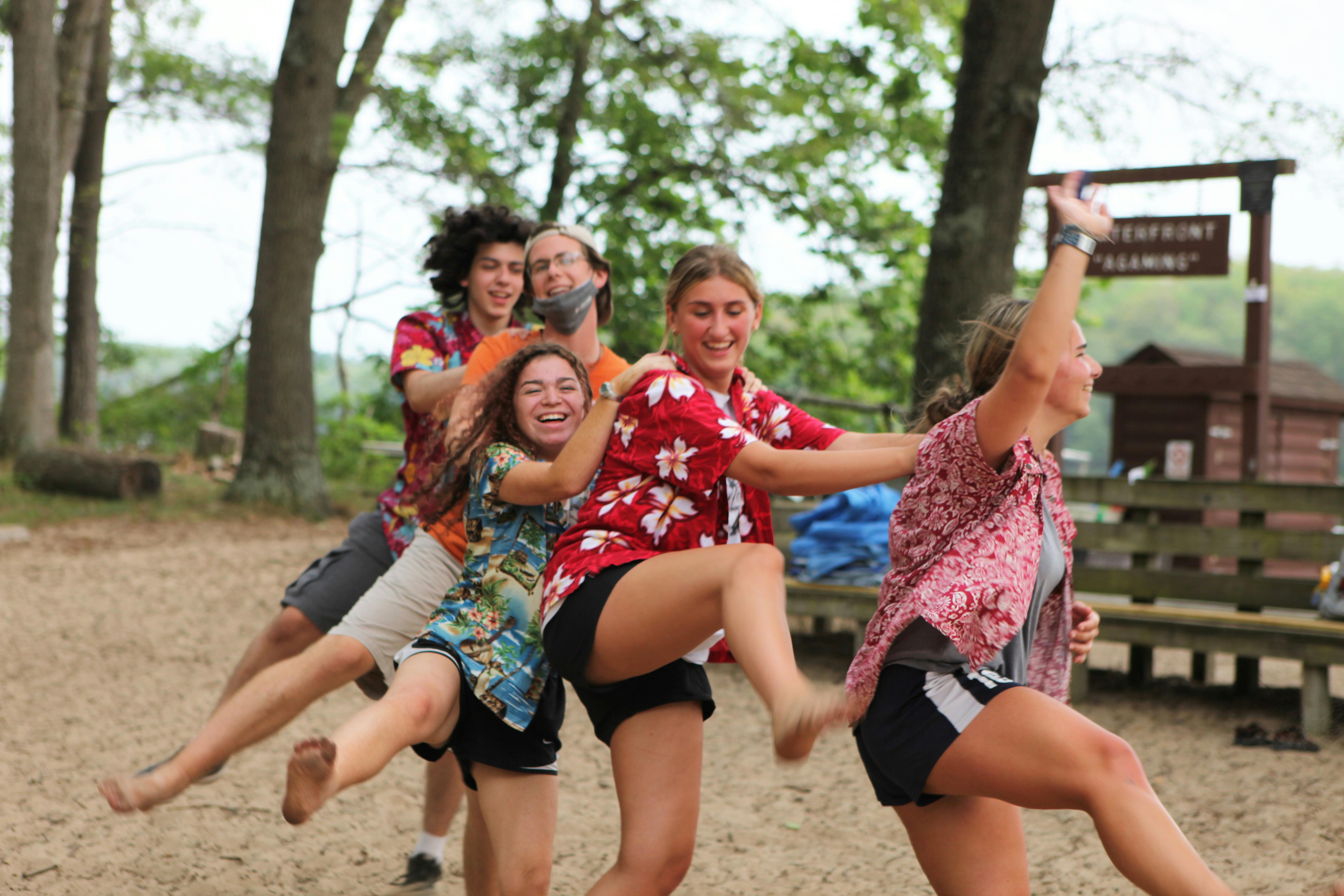 Group of people playing a game outdoors, linked together in a line