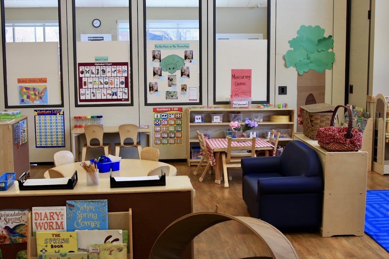 An empty early childhood classroom with multiple learning stations and posters
