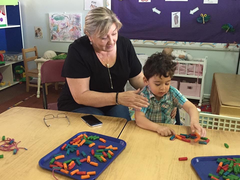 Adult and child at a table with colorful building blocks