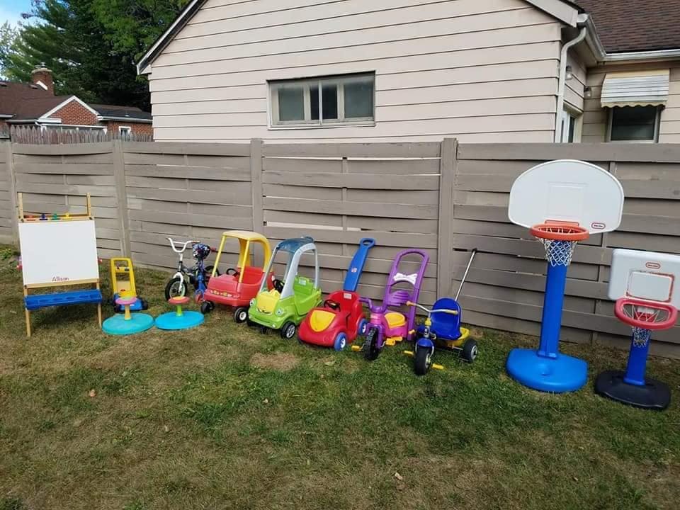 Assortment of children's outdoor toys including ride-ons and basketball hoops
