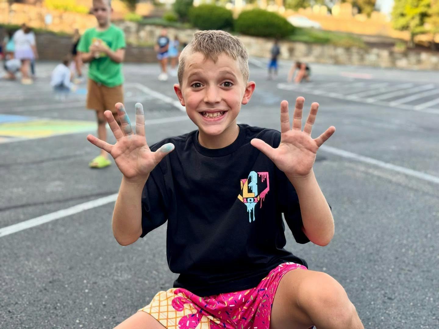 Child showing hands with chalk dust