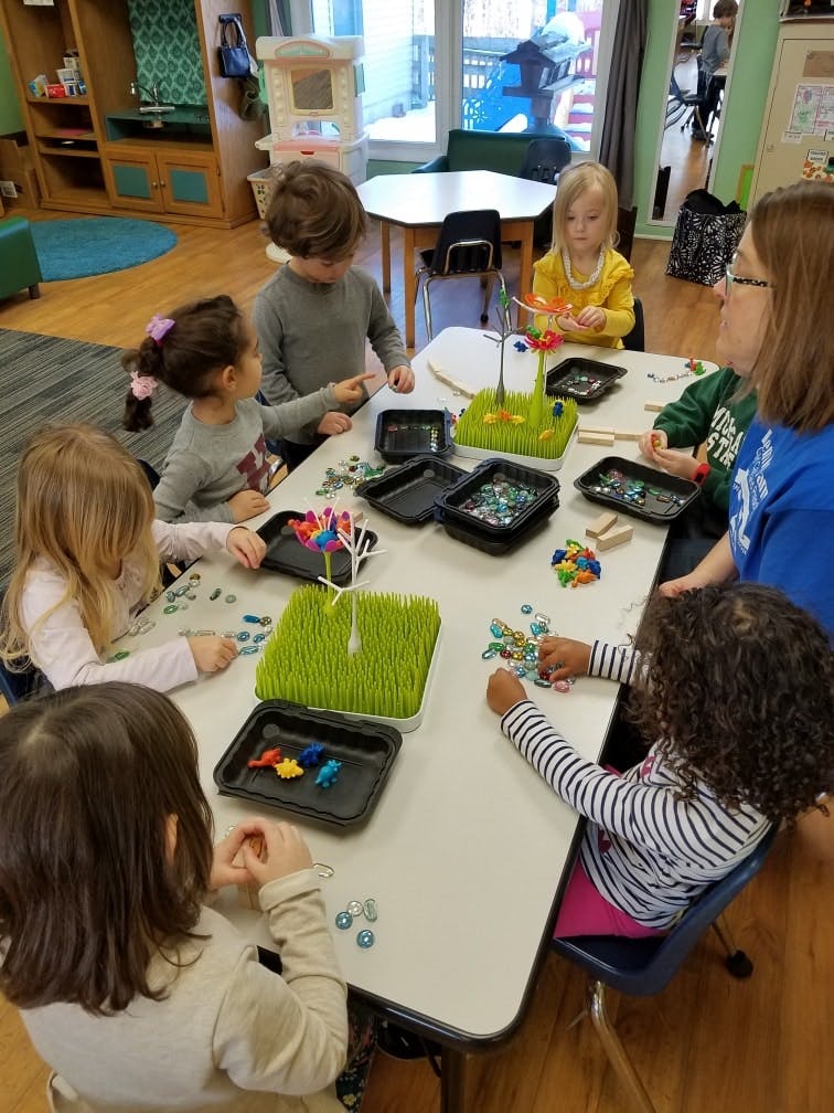 Adult and children at a table with craft supplies