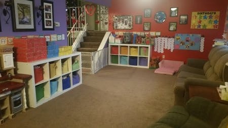 Playroom with storage shelves, stairs, and couches